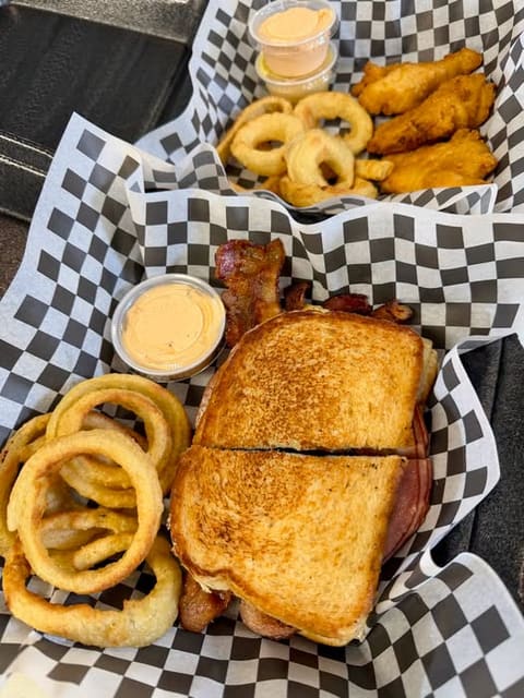 Toasted sandwich with onion rings and sides at Billie-Jo's Place